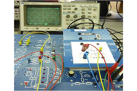 Foto von Schalt-Board mit Kabeln und Monitor dahinter