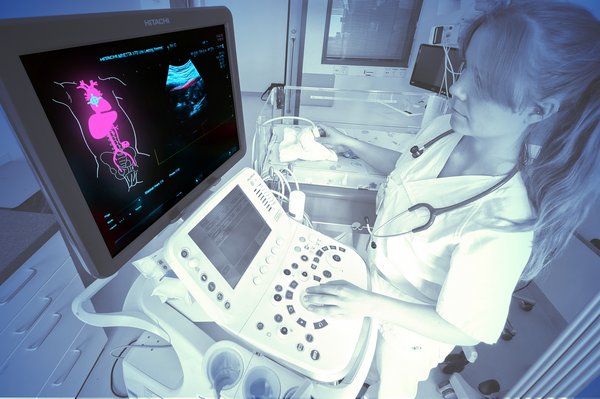 junge Frau an medizinischem Gerät mit Monitor