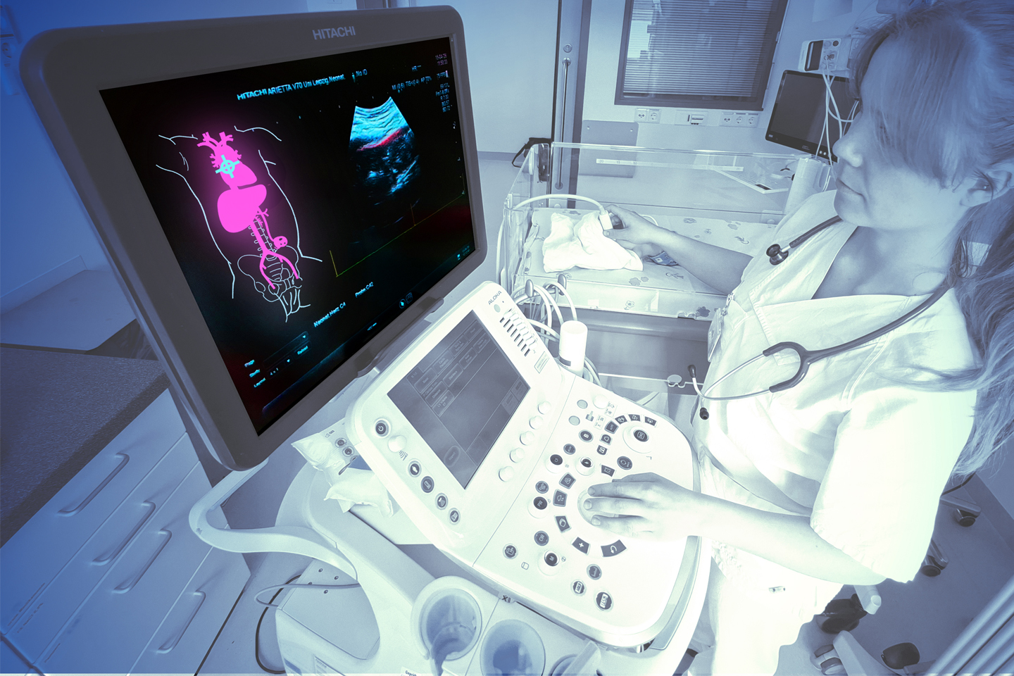Monitor im Vordergrund zeigt Scan von Organen in leuchtenden Farben, daneben steht Wissenschaftlerin